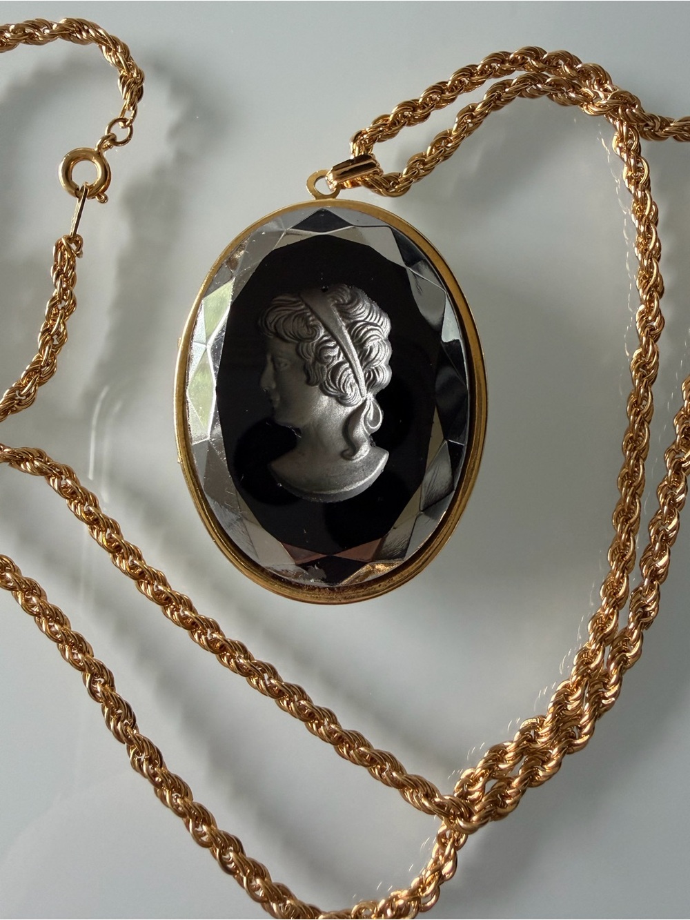 Vintage glass intaglio black and gold cameo locket with chain.